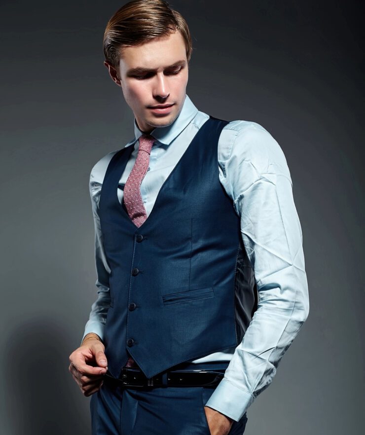 Muškarac u tamno plavom sakou i svetlo plavom košuljom sa rozom kravatom
